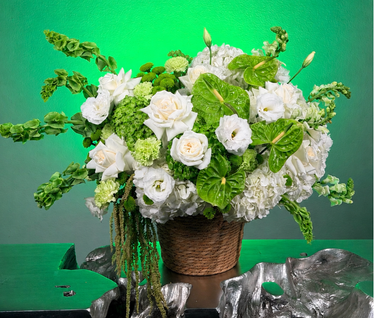 White and green floral arrangement in a woven basket