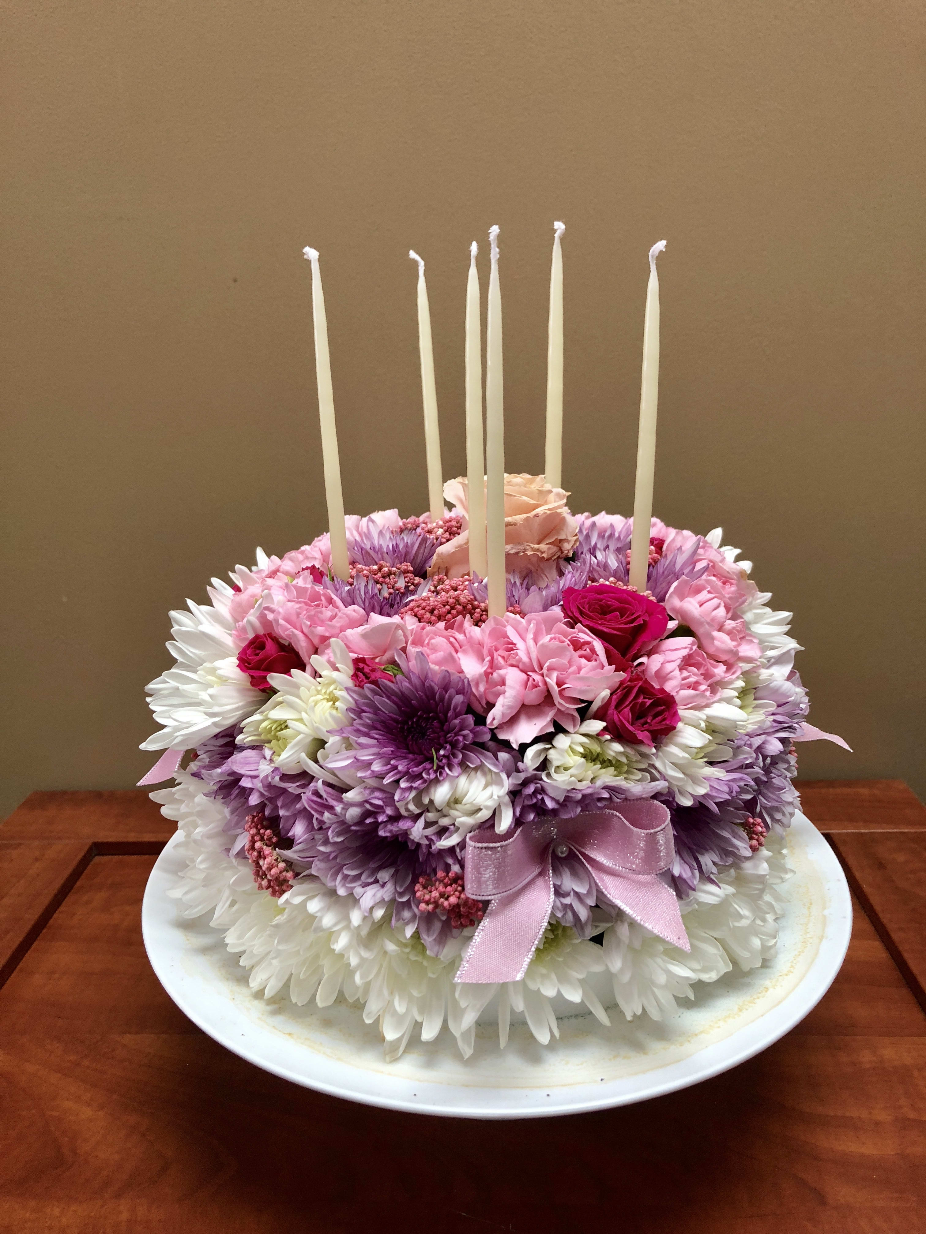 Celebrate the day! - Highlight a special birthday, anniversary or a special event with this unique gift! No calories here.....just beautiful flowers designed to look like a real cake.   The deluxe and premium versions feature ma more elaborate design of roses at the top of the cake, making it even more of a statement!