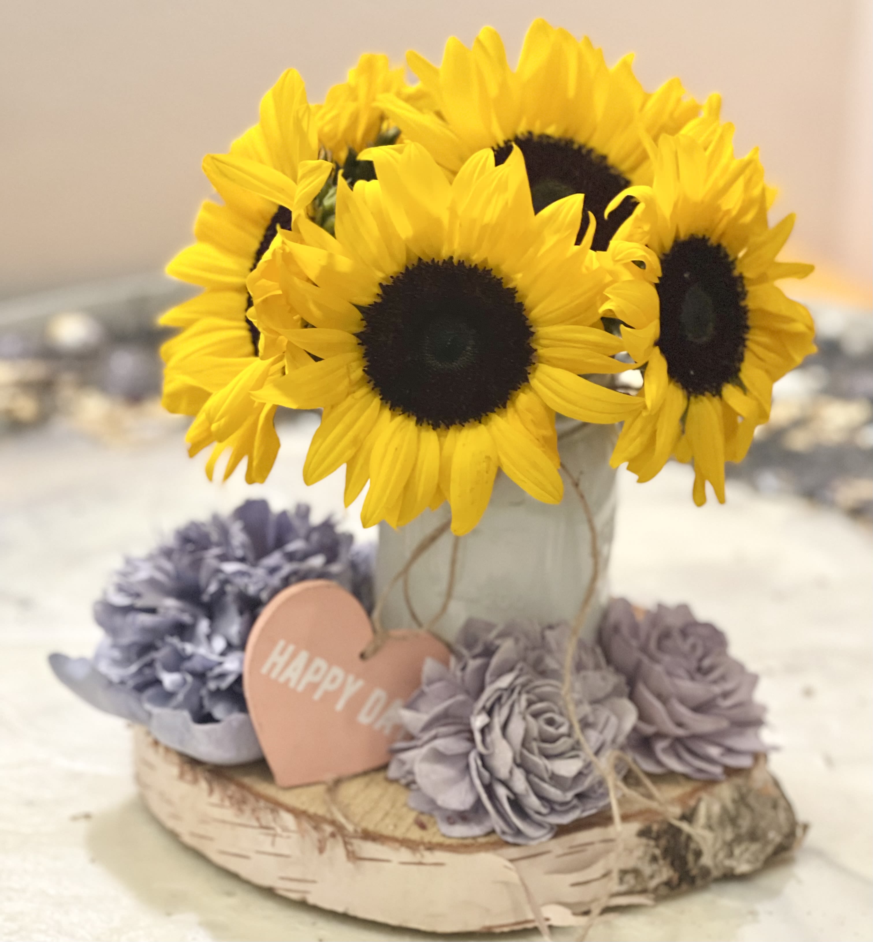 Sunflowers in a birch bark container with lavender flowers and a heart tag
