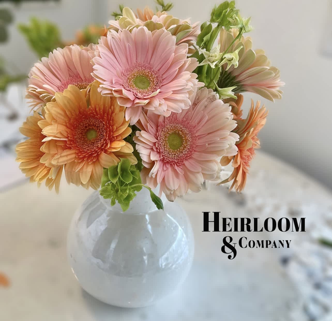 Pink and peach gerbera daisies in a clear round vase