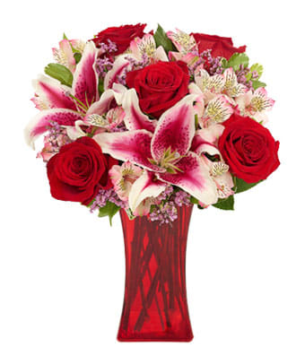 Red roses and pink lilies in a red glass vase