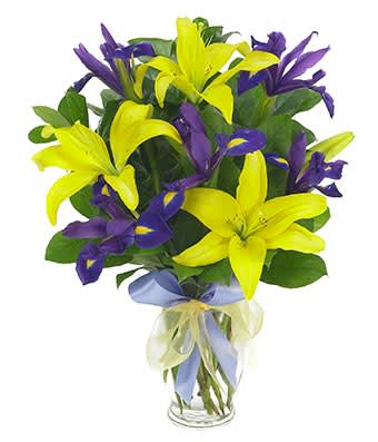 Lily &amp; Iris Surprise - Open your eyes, take a peek and gaze in wonder at this revelation in floral mastery featuring iris and Asiatic lilies complemented by salal tips and yellow sheer accents in a clear fluted vase. Measures 15"H by 10"L.