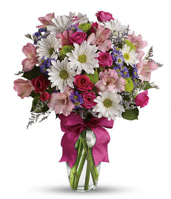 Mixed bouquet of pink roses, white daisies, and purple flowers in a glass vase