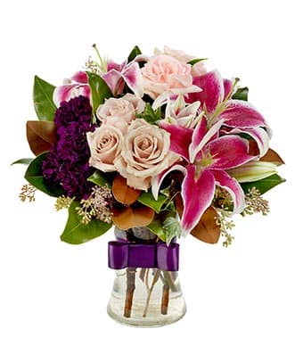 Bouquet of pink lilies and pale roses in a glass vase