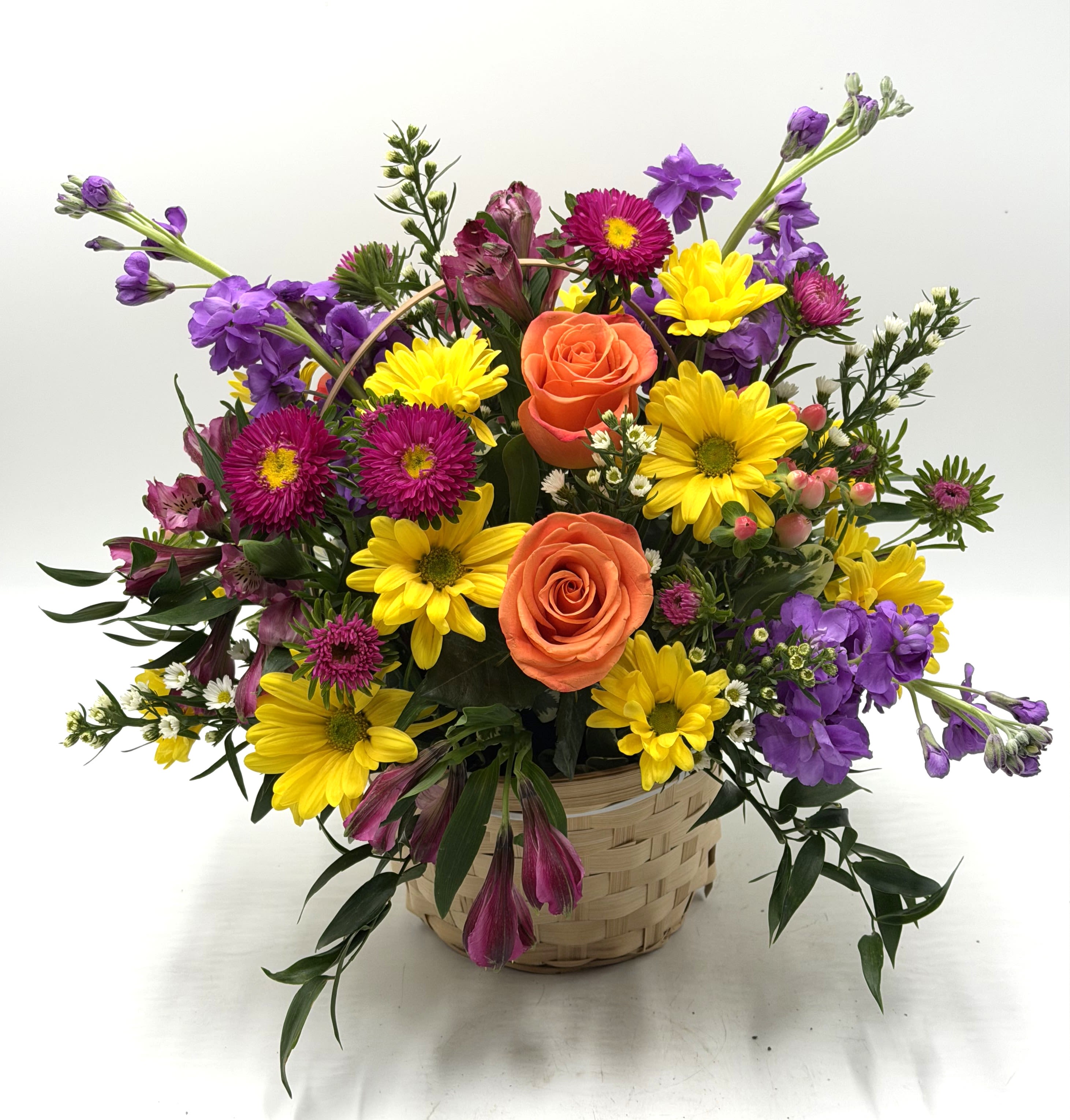 Designer's Choice Basket Arrangement - A mix of fresh, seasonal blooms designed in a handled wicker basket. The designer will pick the freshest blooms in stock to make a one of a kind arrangement!