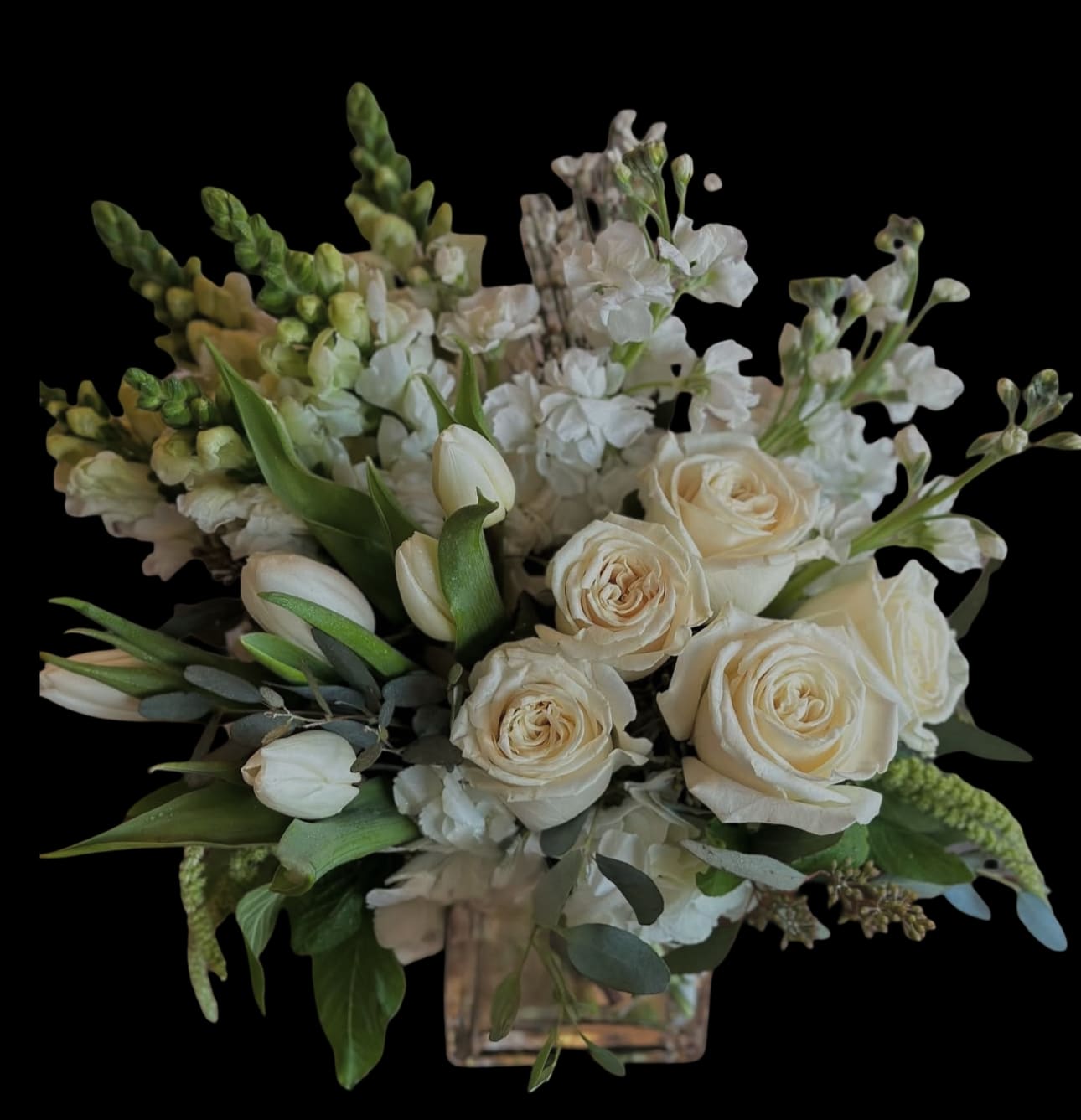 Cream roses and white flowers in a square glass vase