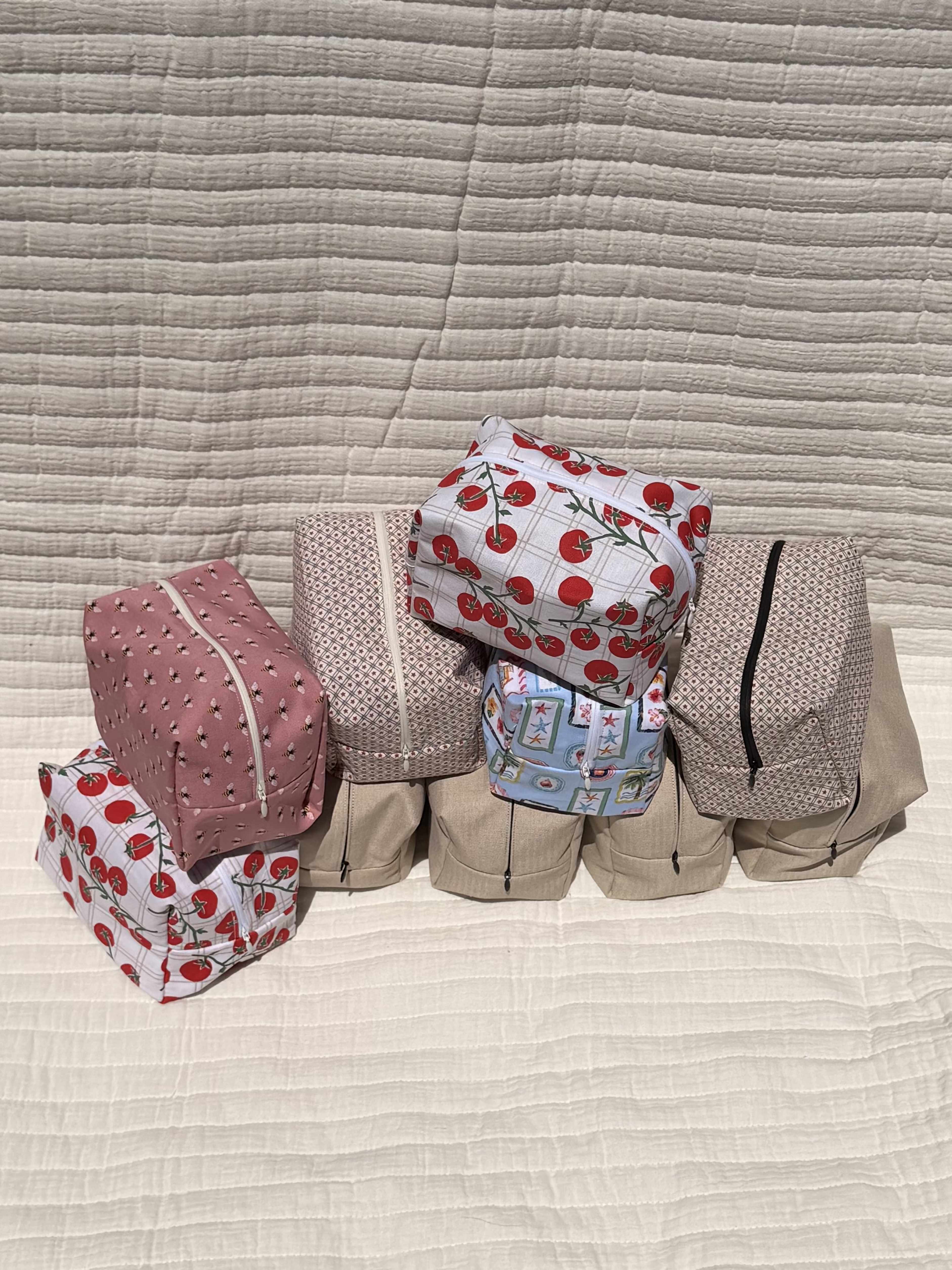 Make- up bags  - A cheerful set of quilted zip pouches designed for everyday organizing and travel-perfect as a gift for someone who loves pretty, practical accessories or as a handy bridesmaid or birthday present. This flower shop take on "Make-up bags" brings soft textures and a playful mix of pink, white, red, blue and yellow tones that read feminine and bright, the kind of find that makes the person you're thinking of smile every time they reach for it.  Each pouch is a small, padded zip pouch with visible zippers and mixed prints-solid pinks, a bright yellow-and-pink accent, dusty-rose patterning and blue and red-and-white designs-arranged on a white quilted surface in the photos. The quilted construction gives a soft, cushioned feel that helps protect cosmetics, travel essentials, chargers or jewelry; sizes are compact for handbags or weekend bags and designed for everyday use rather than display.  Ideal for a friend, bridesmaid, teen, or anyone who appreciates organized, pretty storage, these pouches make a thoughtful, useful gift that says you care about both style and function. Order multiple prints to create a coordinated set; spot-clean or gentle wash as needed to preserve the quilting and colors.
