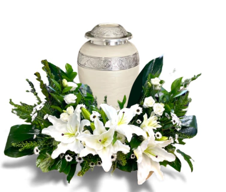 White lilies arranged around a cream urn