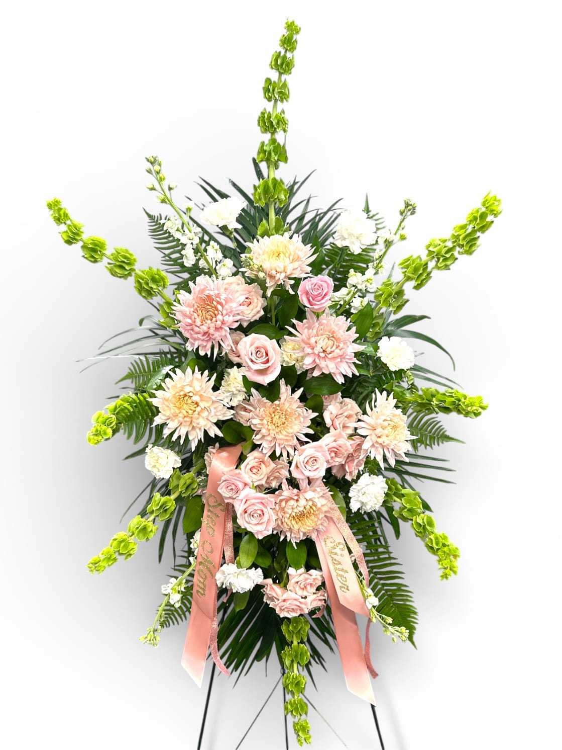 Standing floral spray with pink roses, pale chrysanthemums, and green spikes