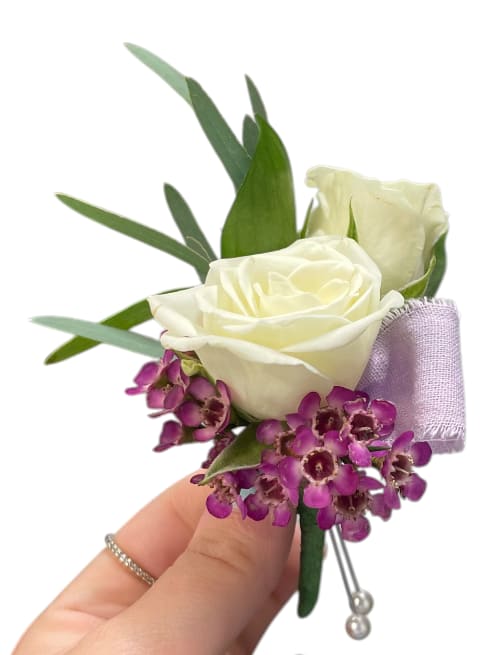 White rose boutonniere with purple accent flowers and ribbon