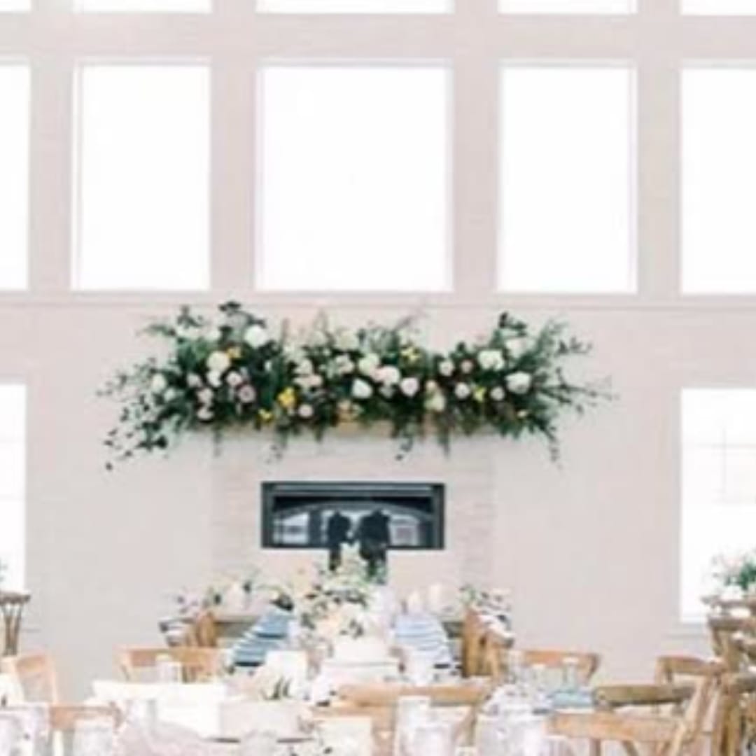 Large floral garland above a fireplace in a bright room