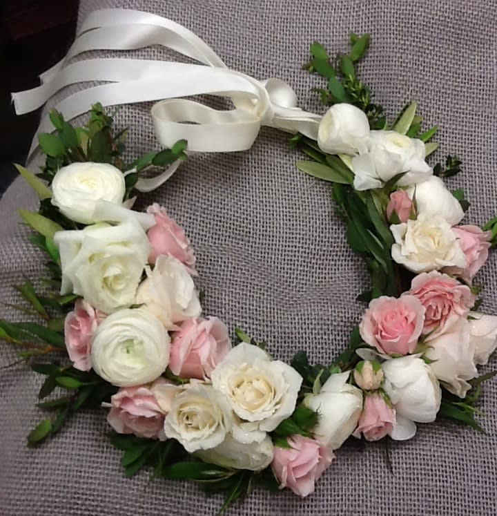 Floral wreath with white and pink roses tied with a white ribbon