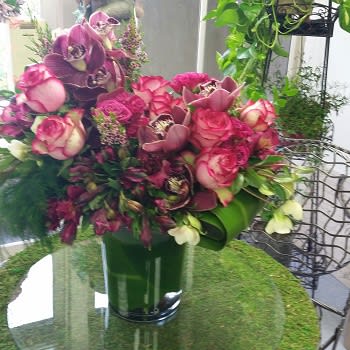 Pink and purple floral arrangement in a green vase
