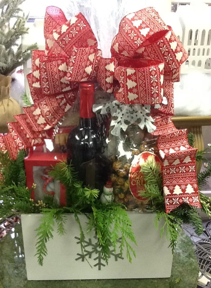Christmas gift basket with wine, snacks, and red patterned bows