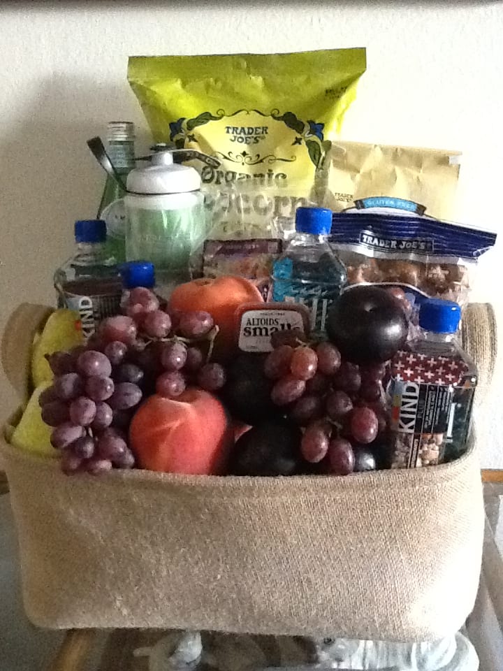 Gift basket filled with fruit, snacks, and bottled drinks