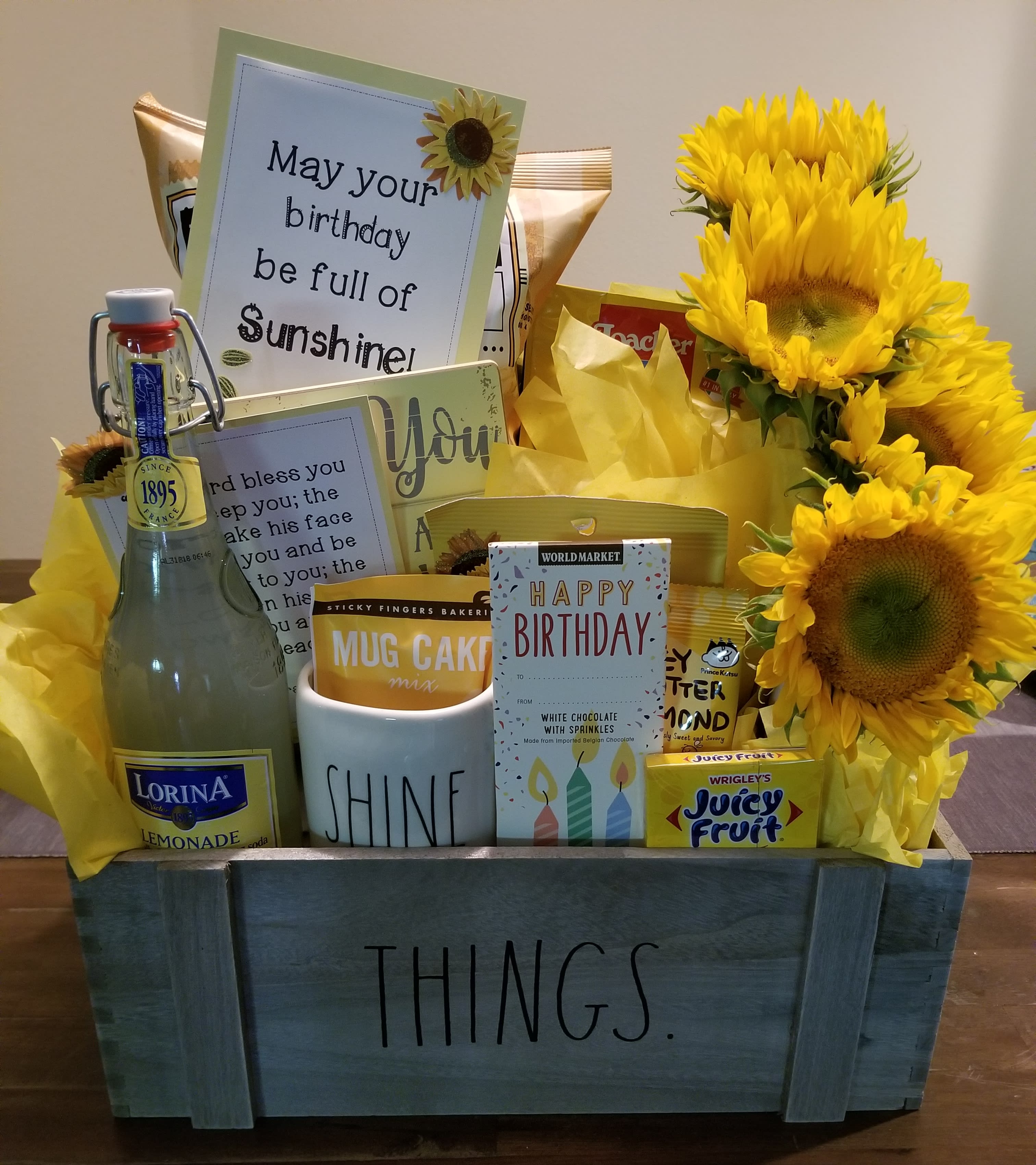 Gift basket with sunflowers, cards, candy, and a bottle of lemonade