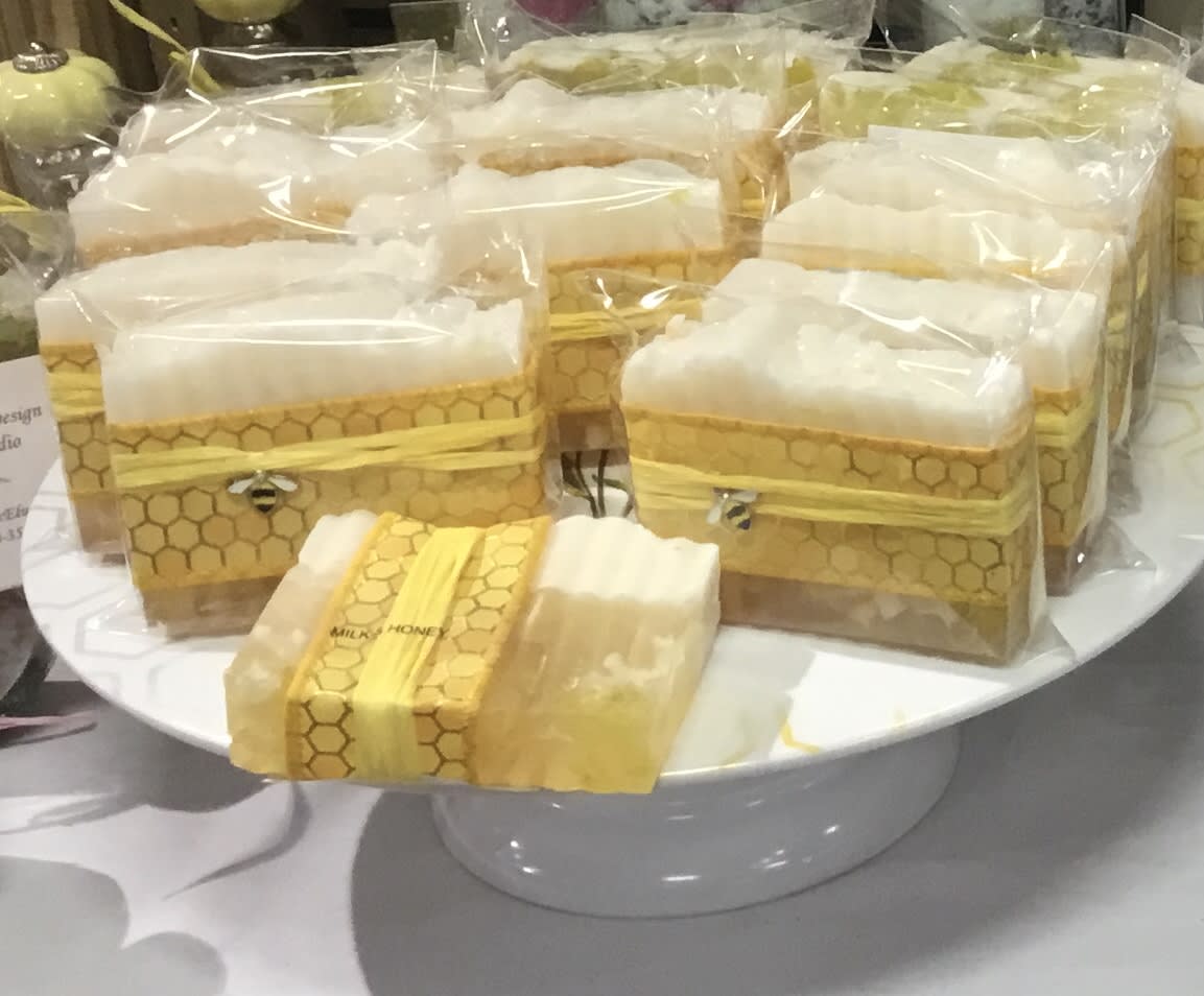 Wrapped honeycomb-pattern gift boxes on a white pedestal