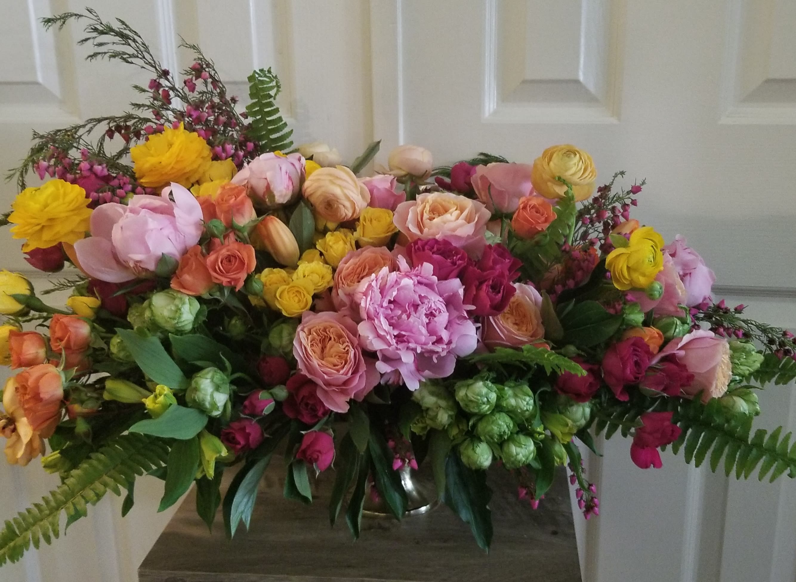 Large bouquet of pink, yellow, and peach flowers in a vase