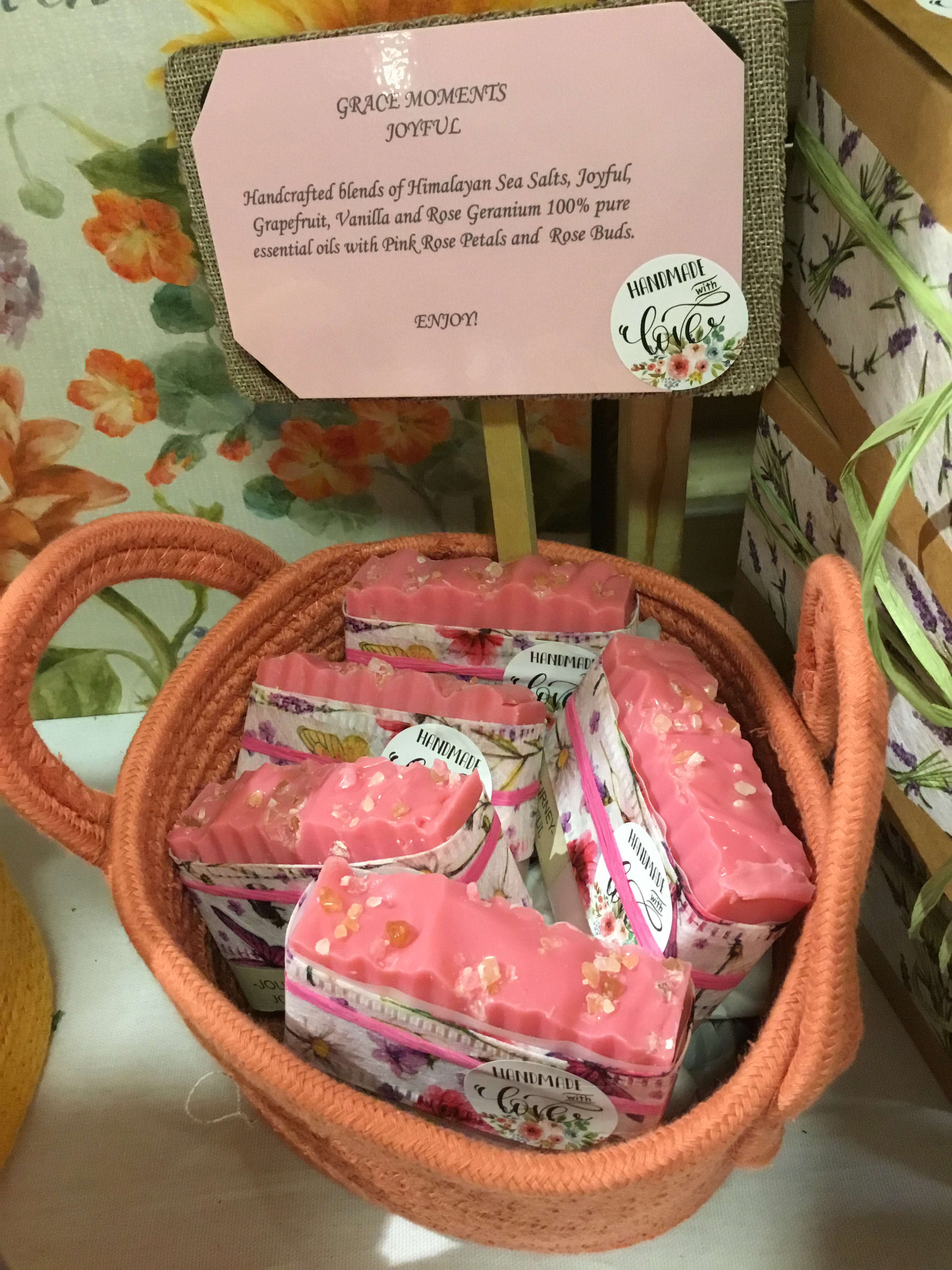 Basket of pink handmade soaps with floral packaging