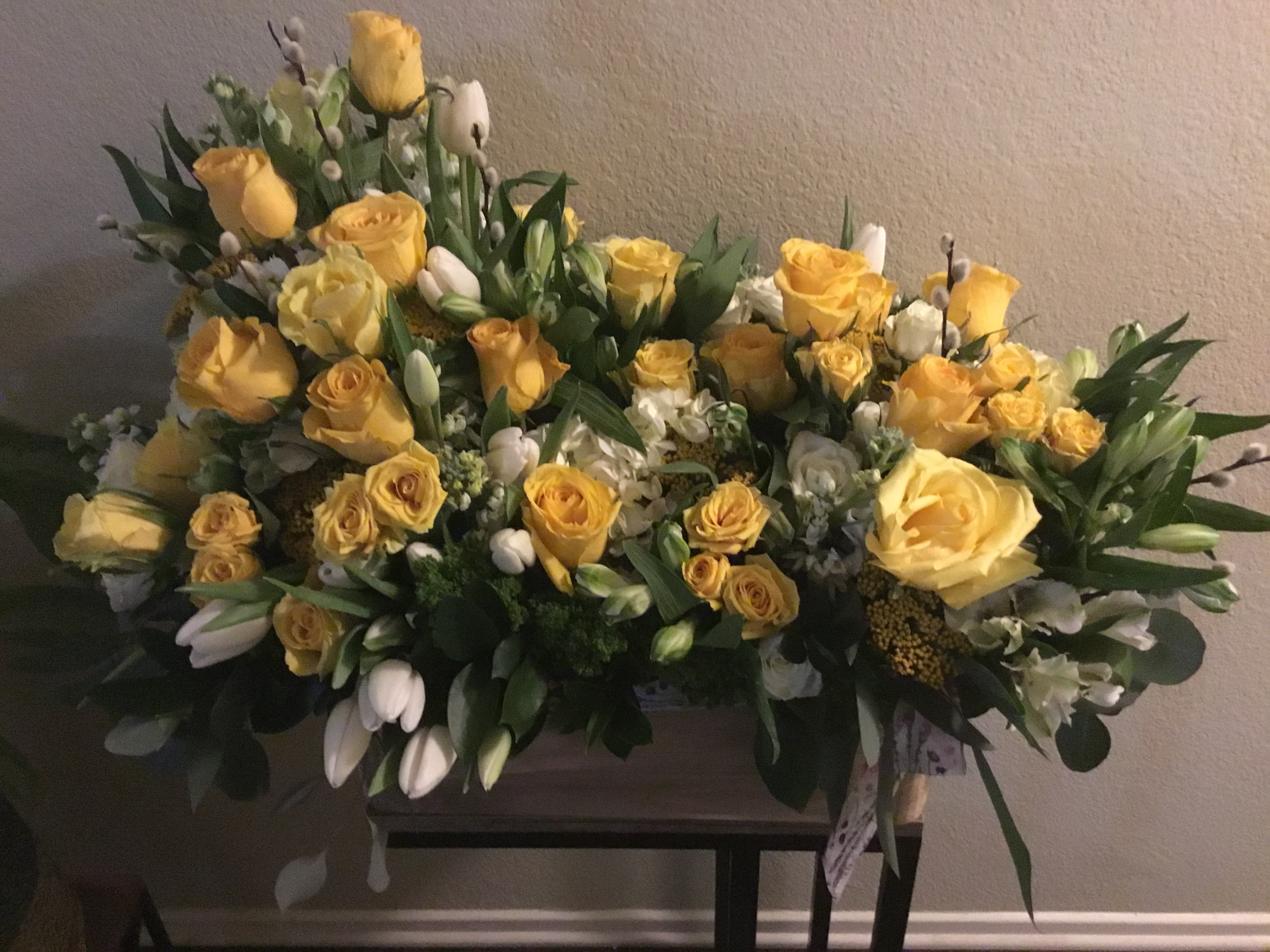 Large yellow rose arrangement with white flowers and greenery