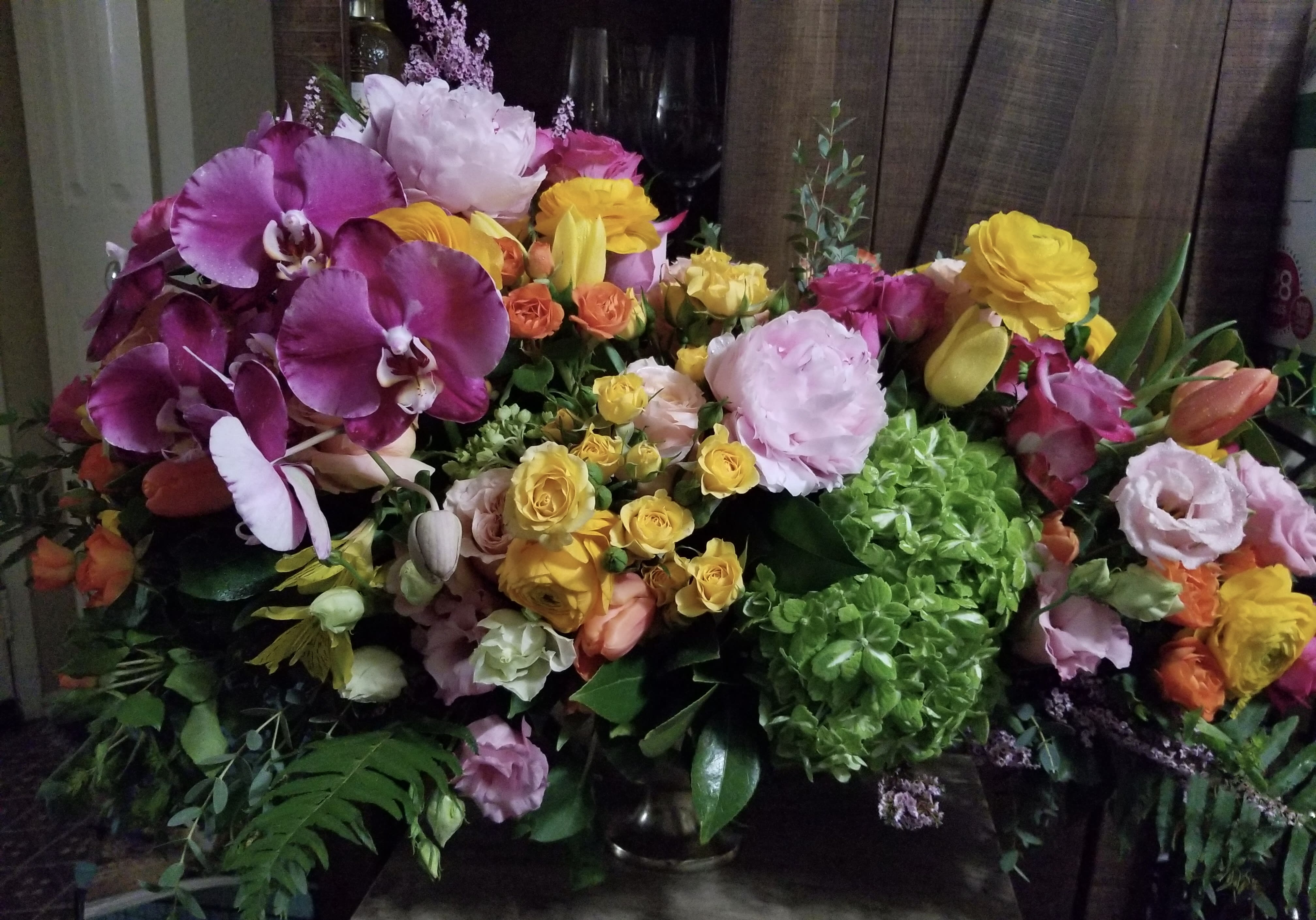 Mixed bouquet with purple orchids, yellow roses, and pink blooms