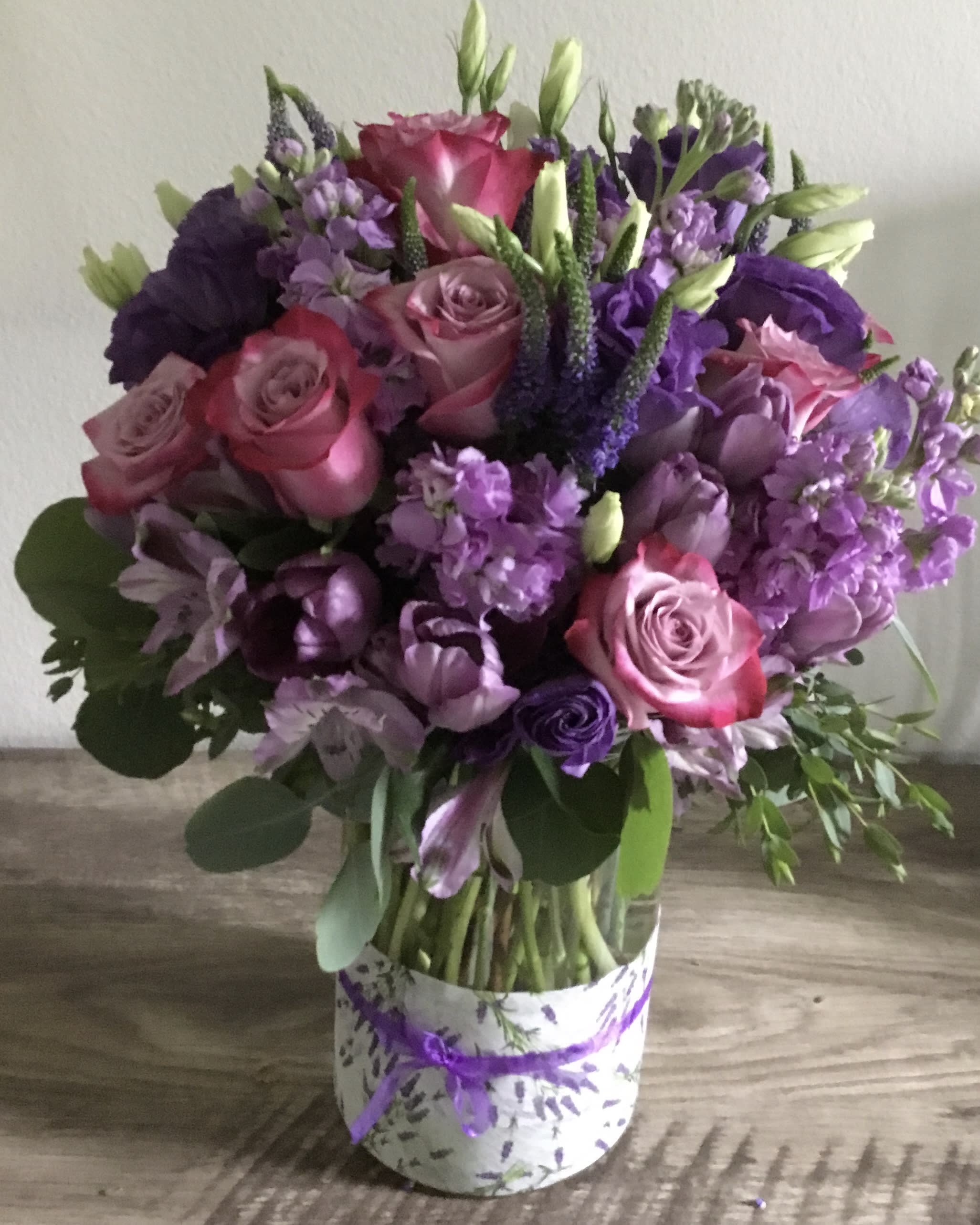 Bouquet of pink and purple flowers in a patterned box