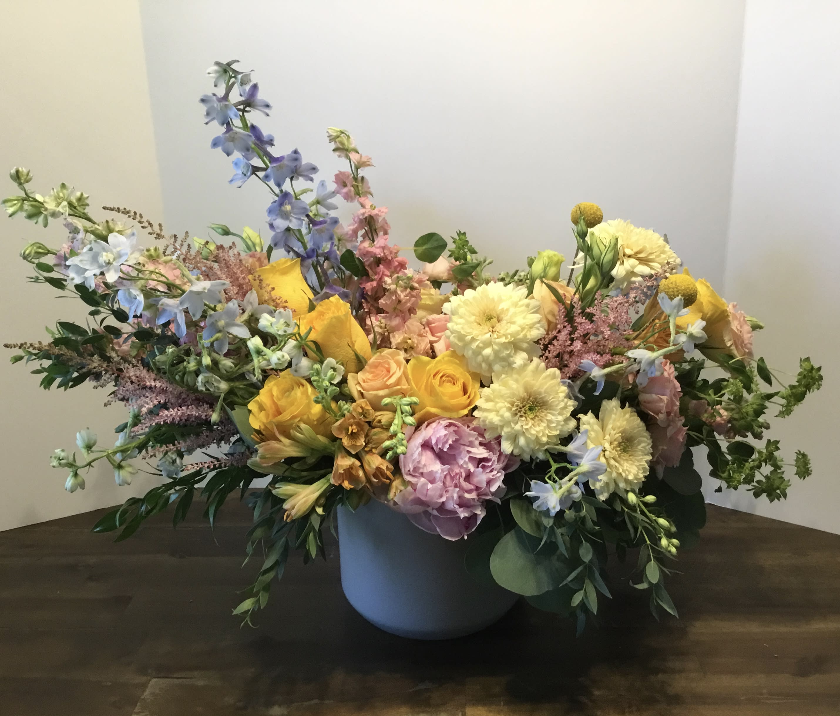Mixed bouquet in a gray vase with yellow, pink, and blue flowers