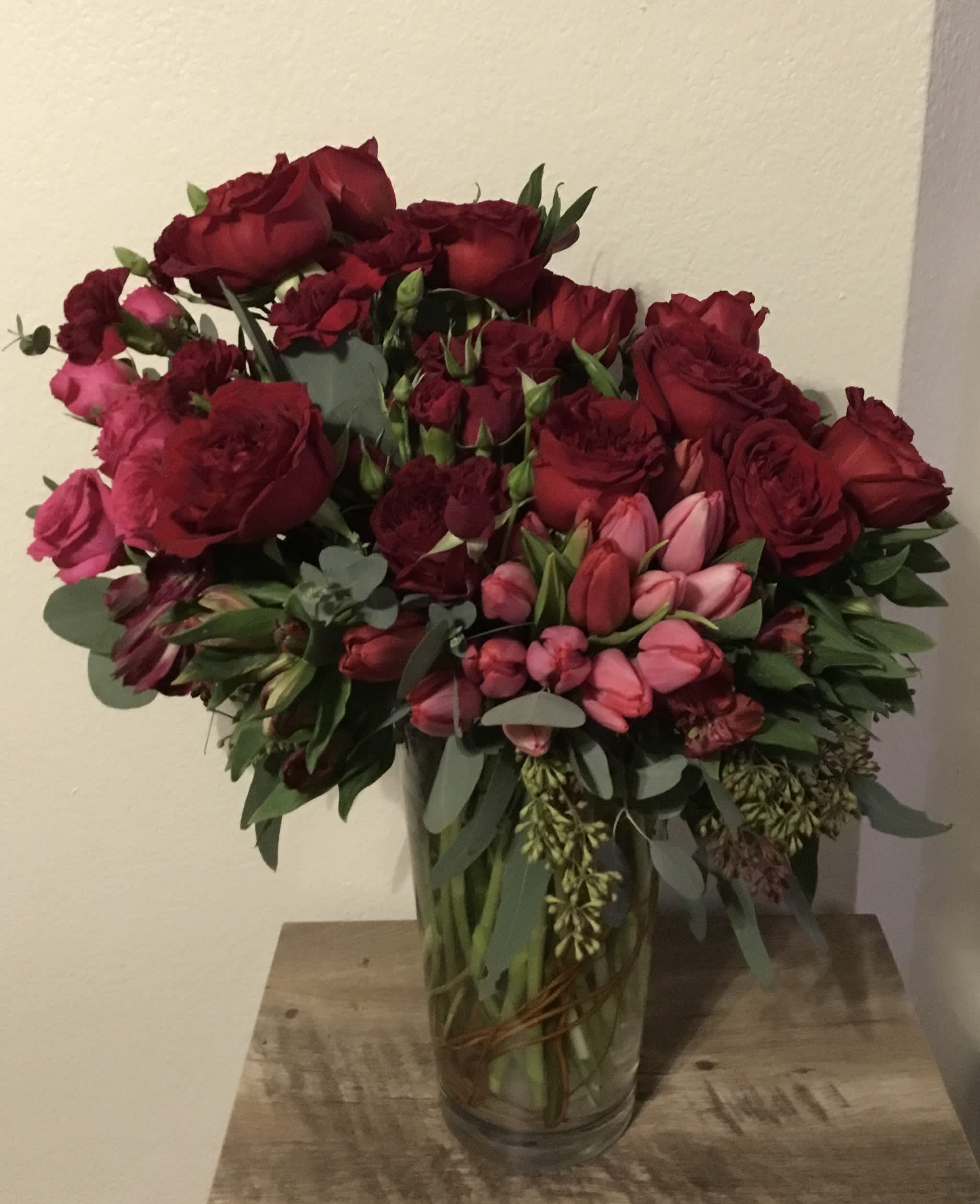 Bouquet of red and pink roses in a clear glass vase