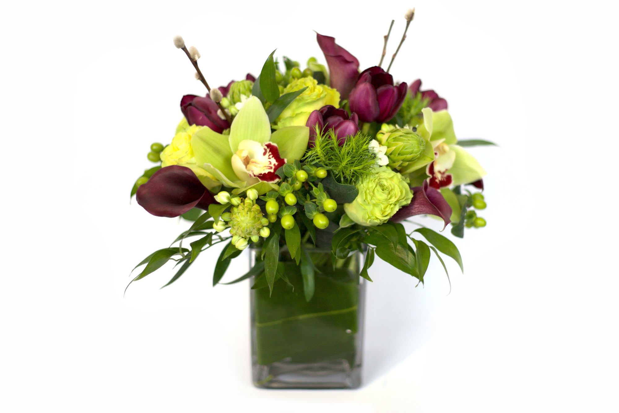 Bouquet of green and burgundy flowers in a square glass vase