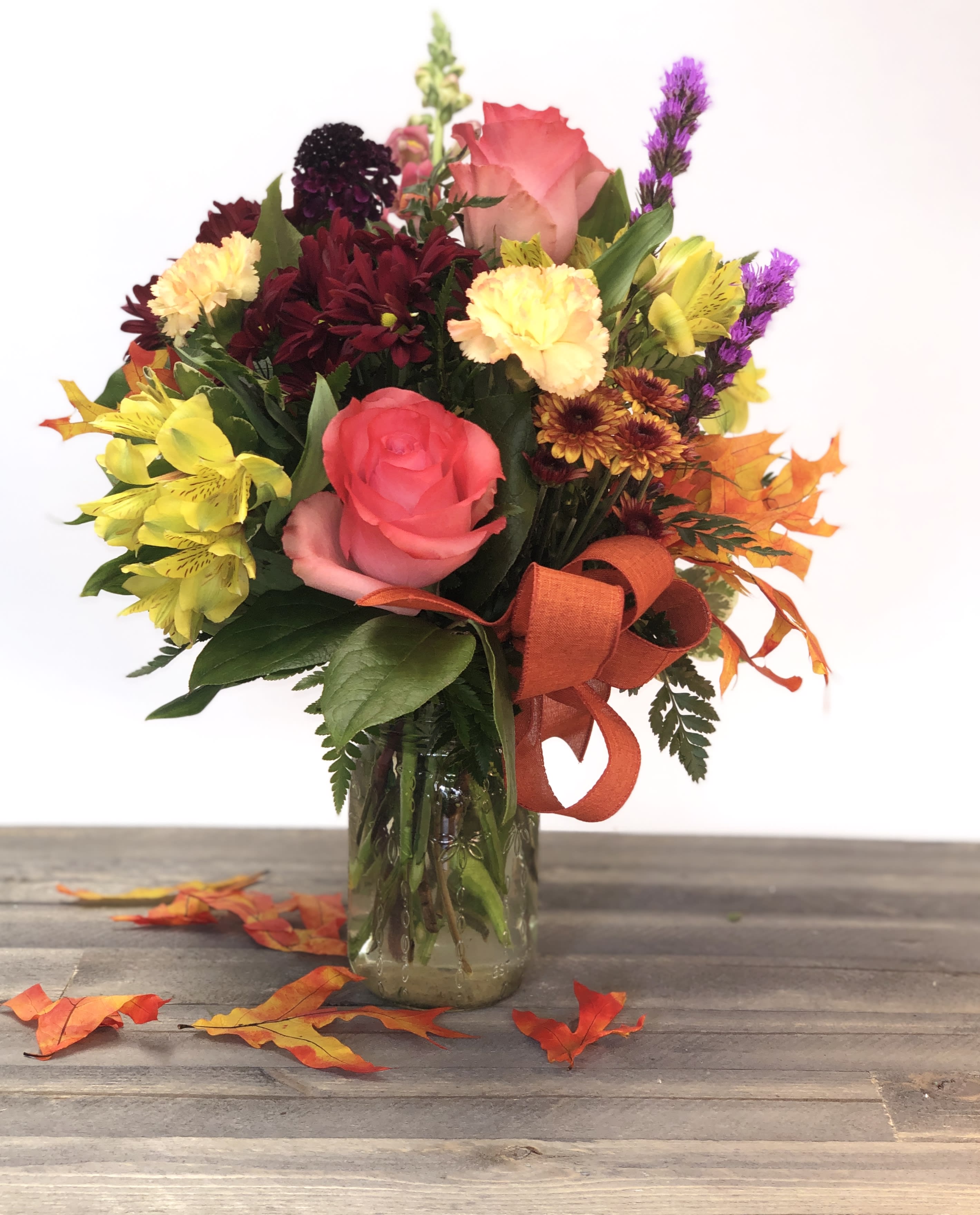 Autumn Breeze - Fall colors arranged in a vase accented with a fall bow.