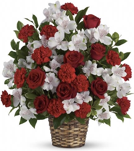 Red roses and carnations with white orchids in a woven basket