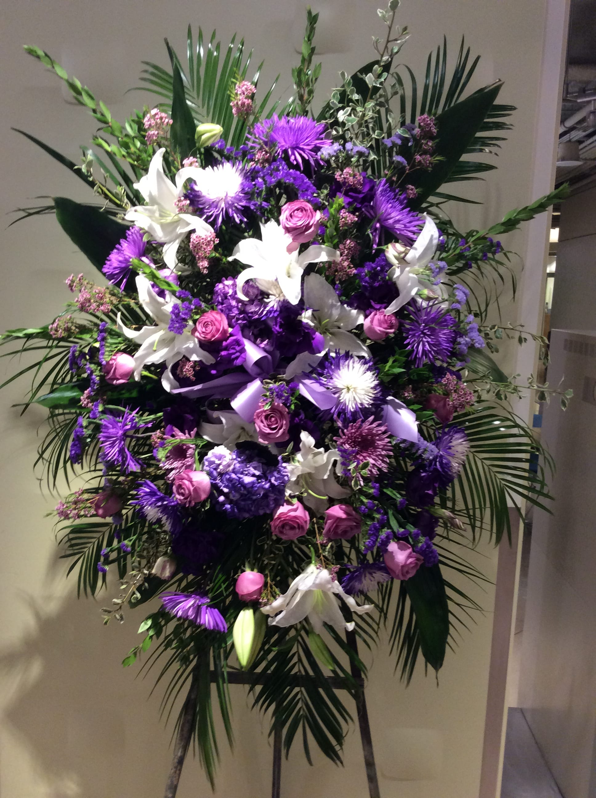 Large purple and white floral standing spray with lilies and roses
