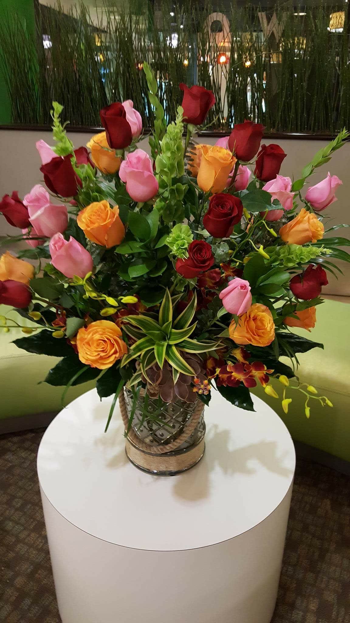 Mixed rose arrangement in a decorative glass vase