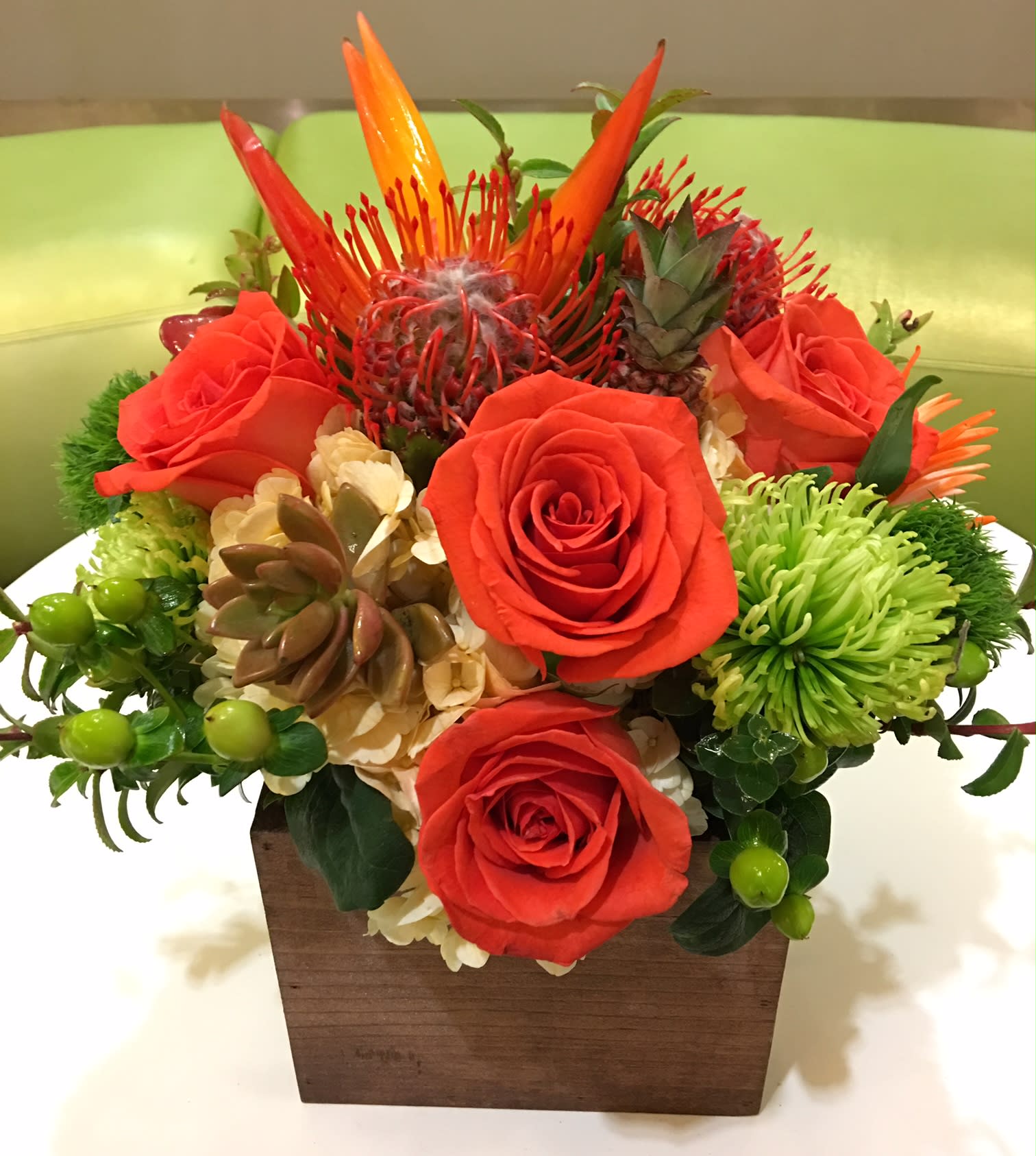 Orange roses and tropical blooms in a wooden box
