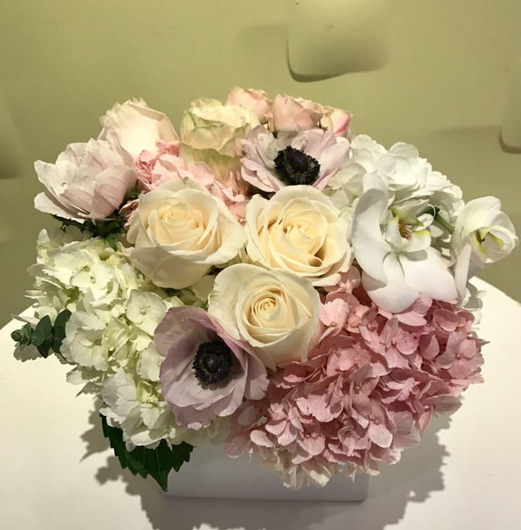 Pastel bouquet of roses, hydrangeas, and anemones in a white box