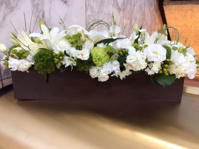 White floral arrangement in a rectangular brown container