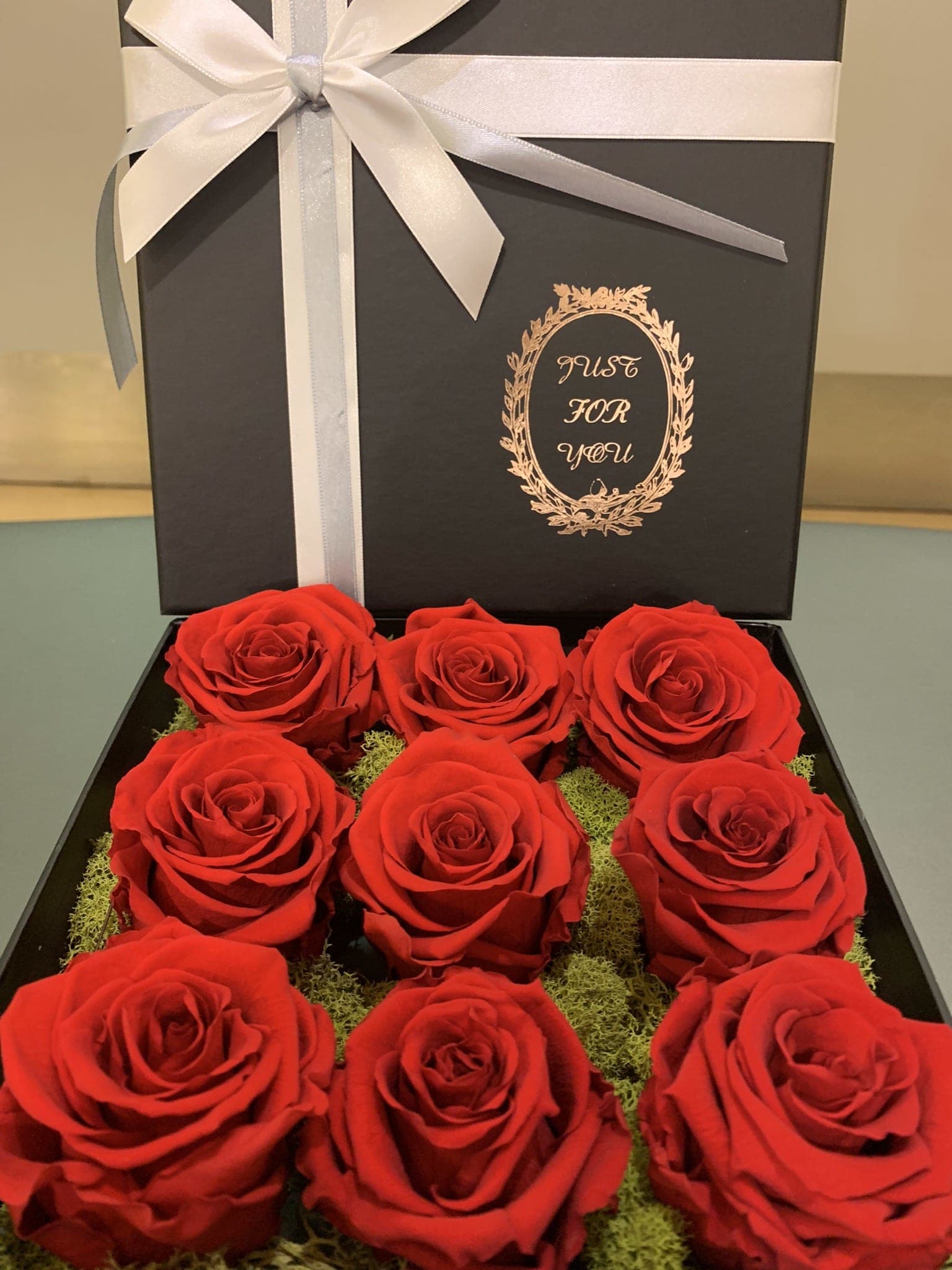 Box of red roses with a white ribbon and bow