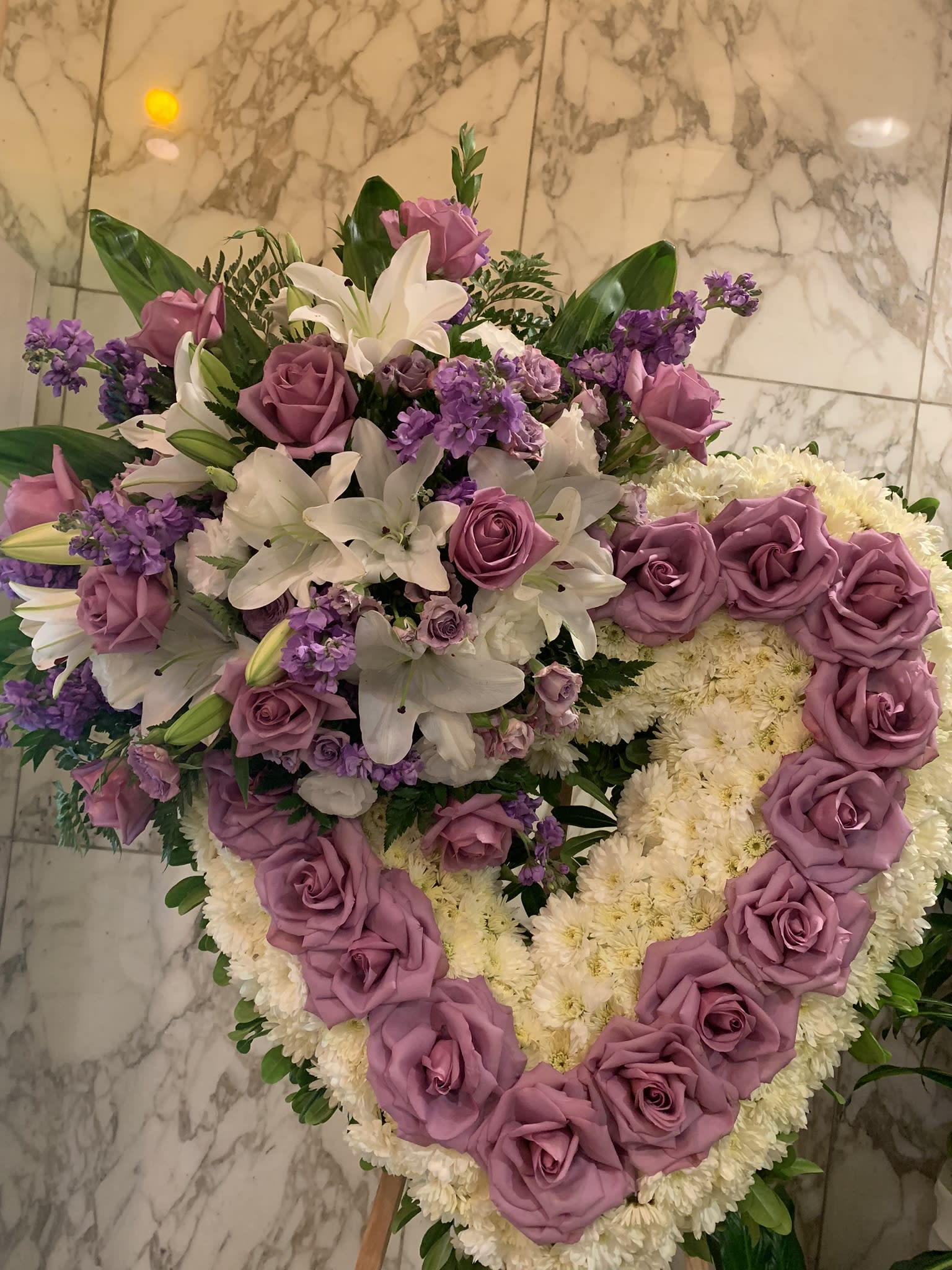Heart-shaped floral arrangement with lavender roses and white lilies