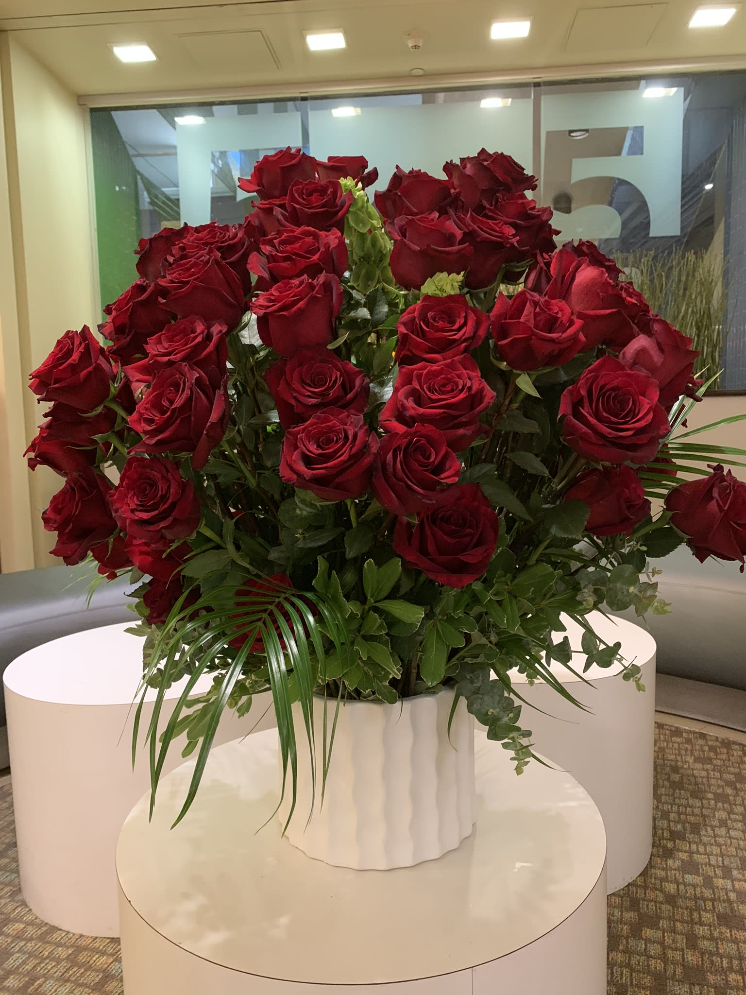 Large bouquet of red roses in a white vase