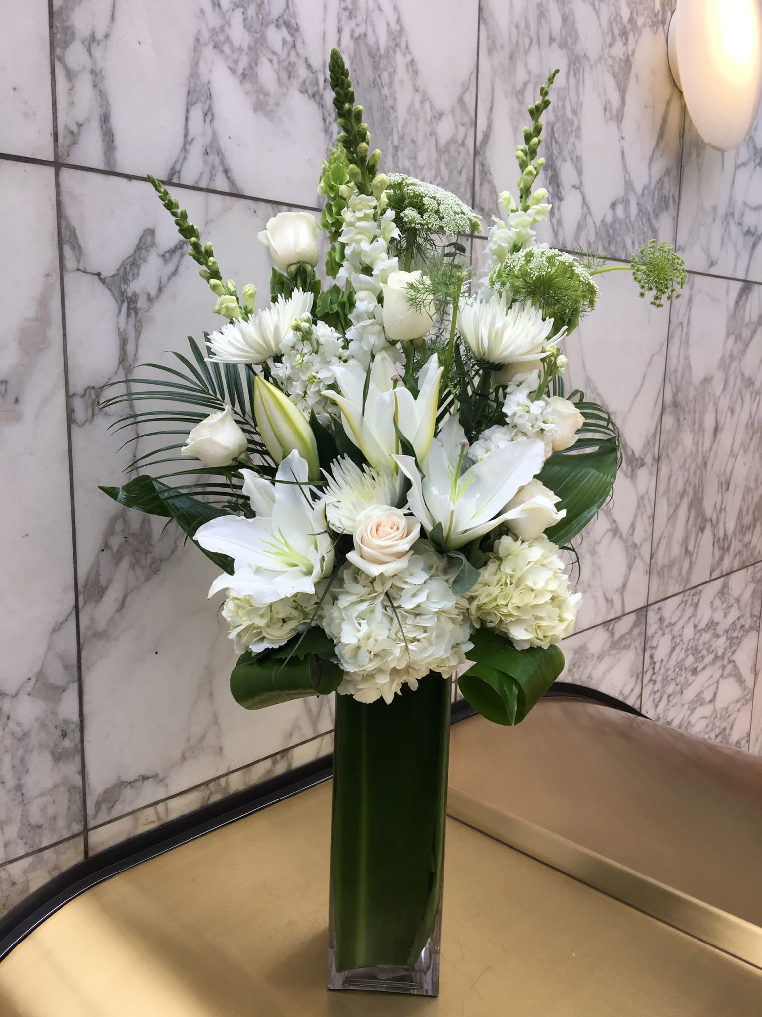 White floral arrangement in a tall green vase