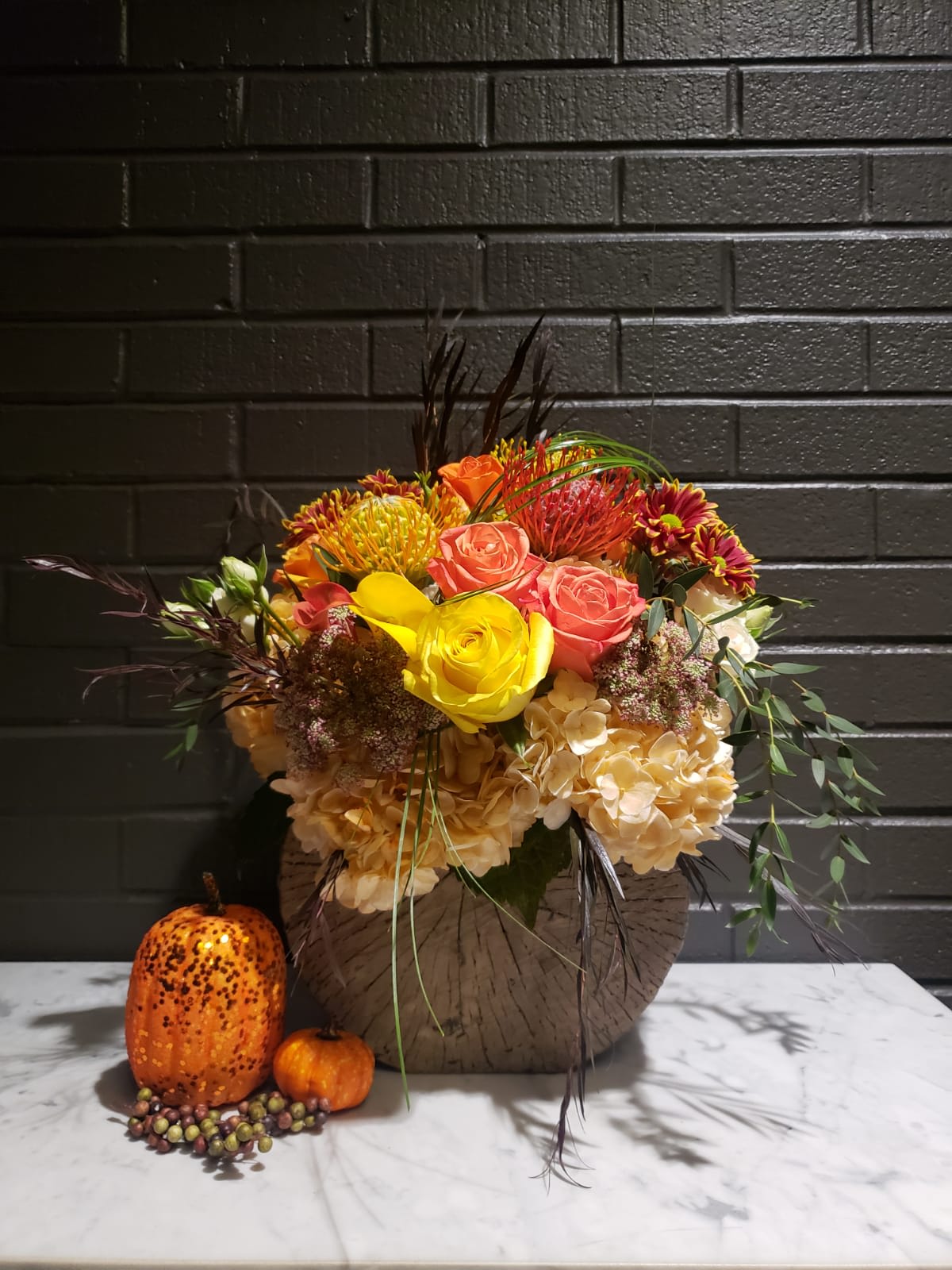 Fall inspiration  - Created in a cement vase fill assorted fall colors flowers make this arrangement beautiful gift for home or office 