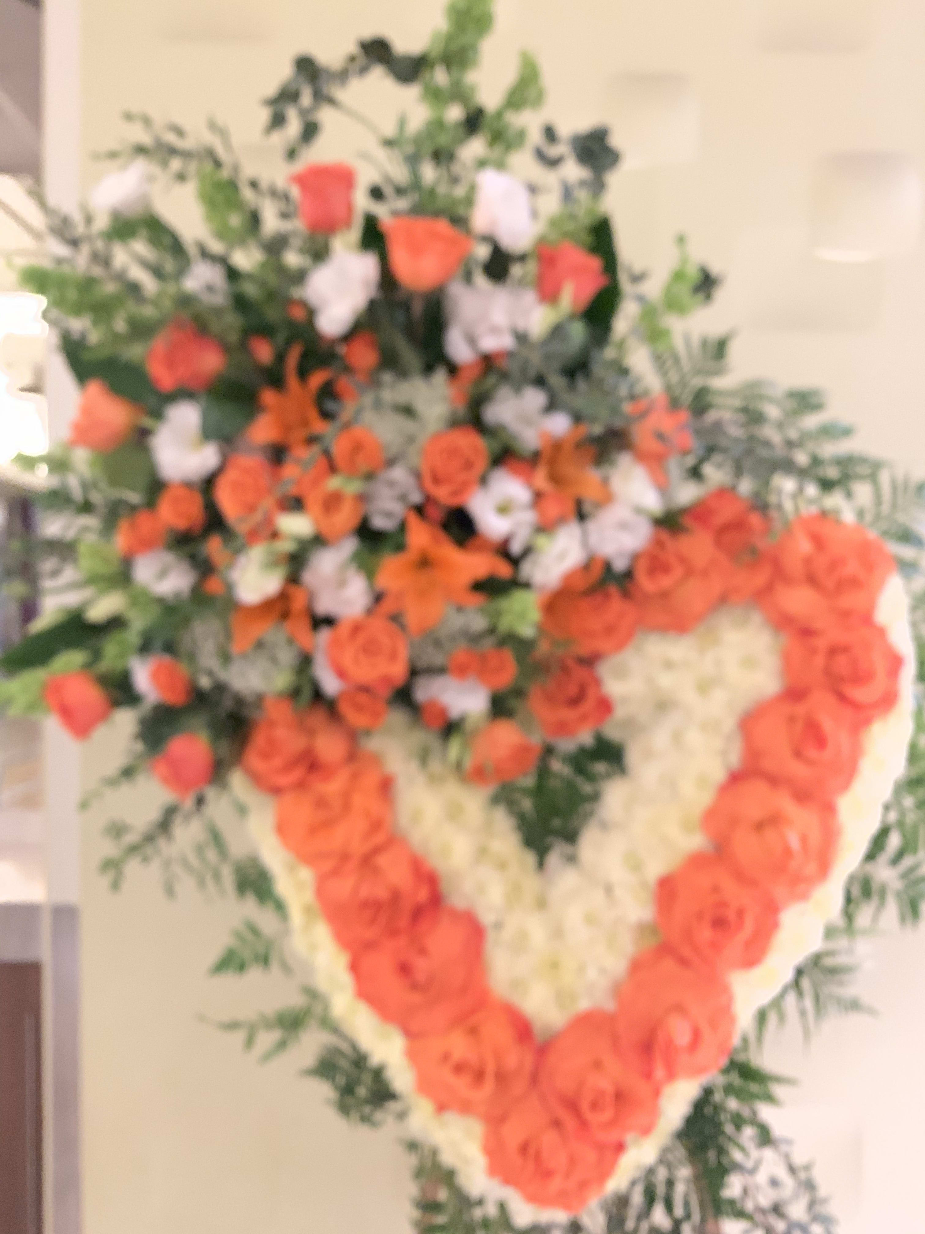 Heart-shaped floral spray with orange and white roses