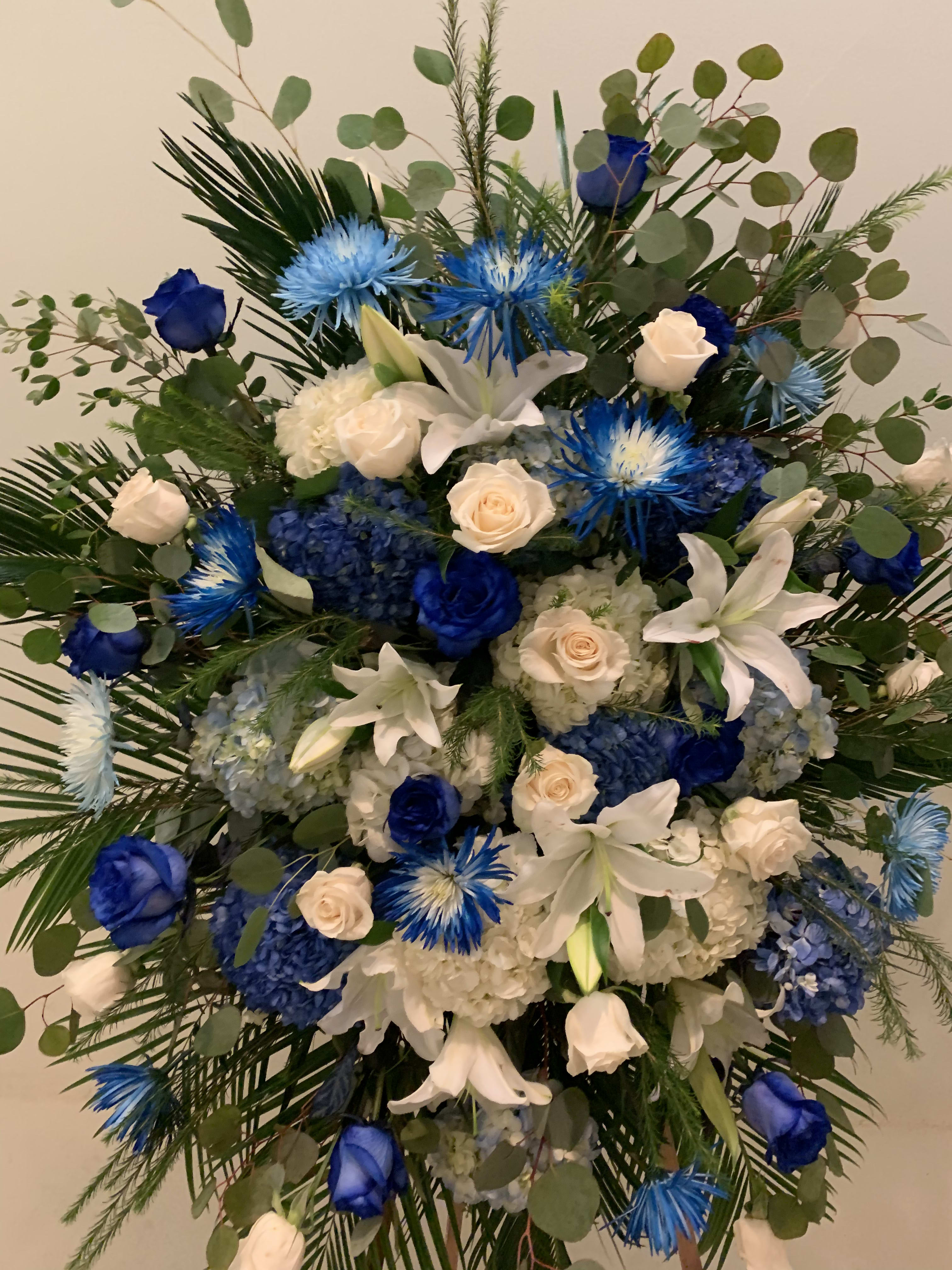 Blue and white floral standing spray with roses and lilies