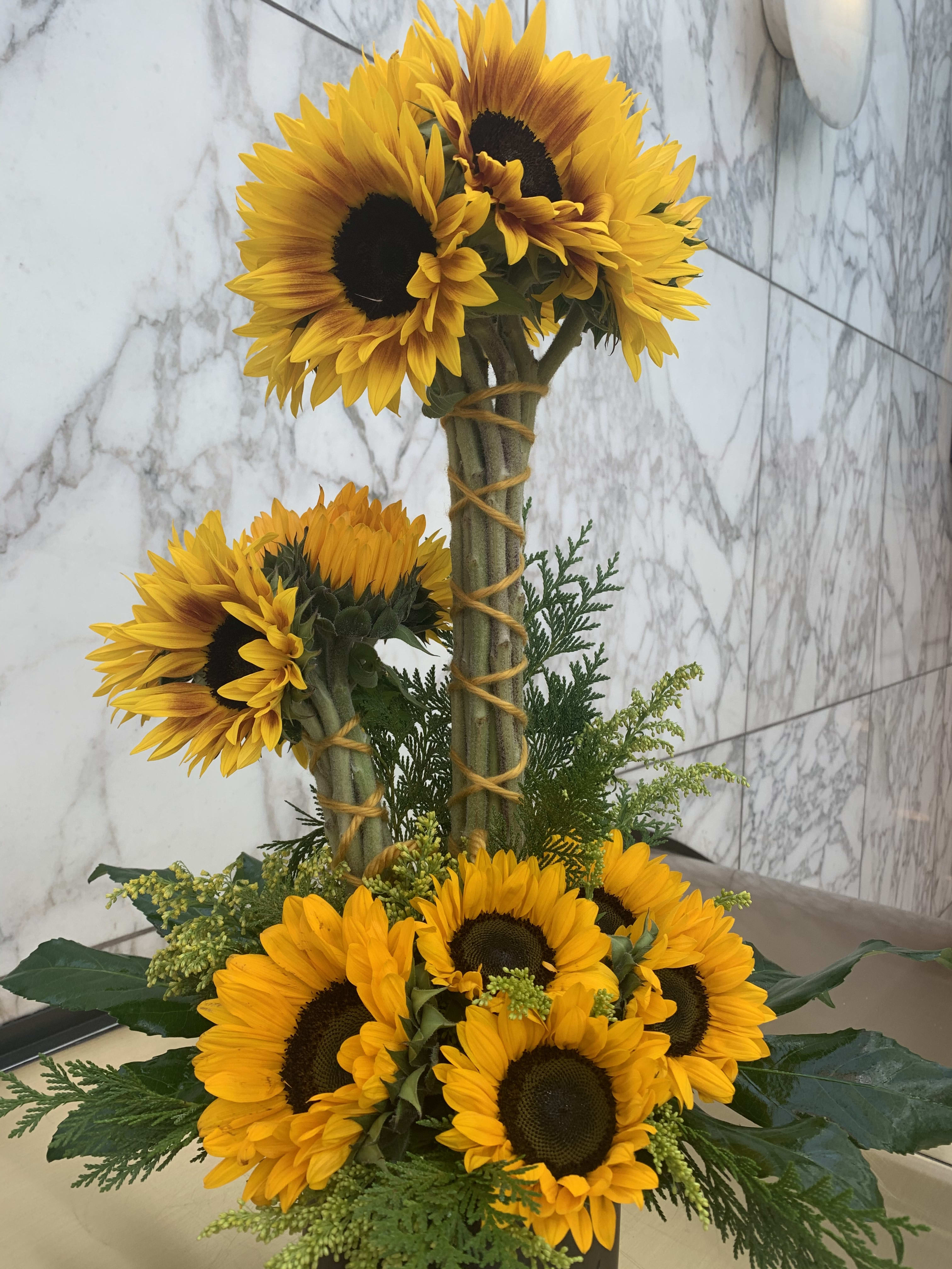 Sunflower arrangement with two tiers of blooms and greenery