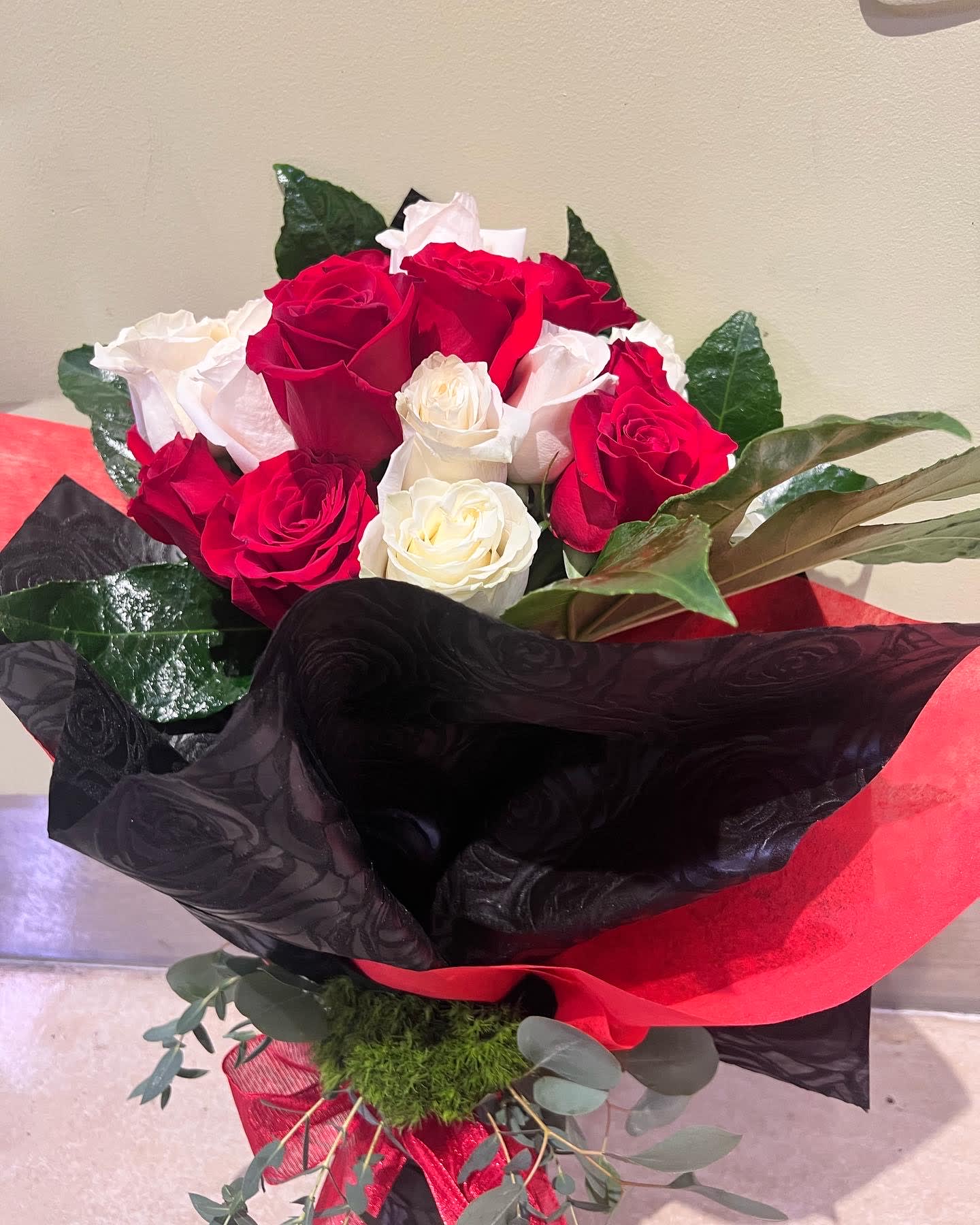 Bouquet of red and white roses wrapped in black and red paper
