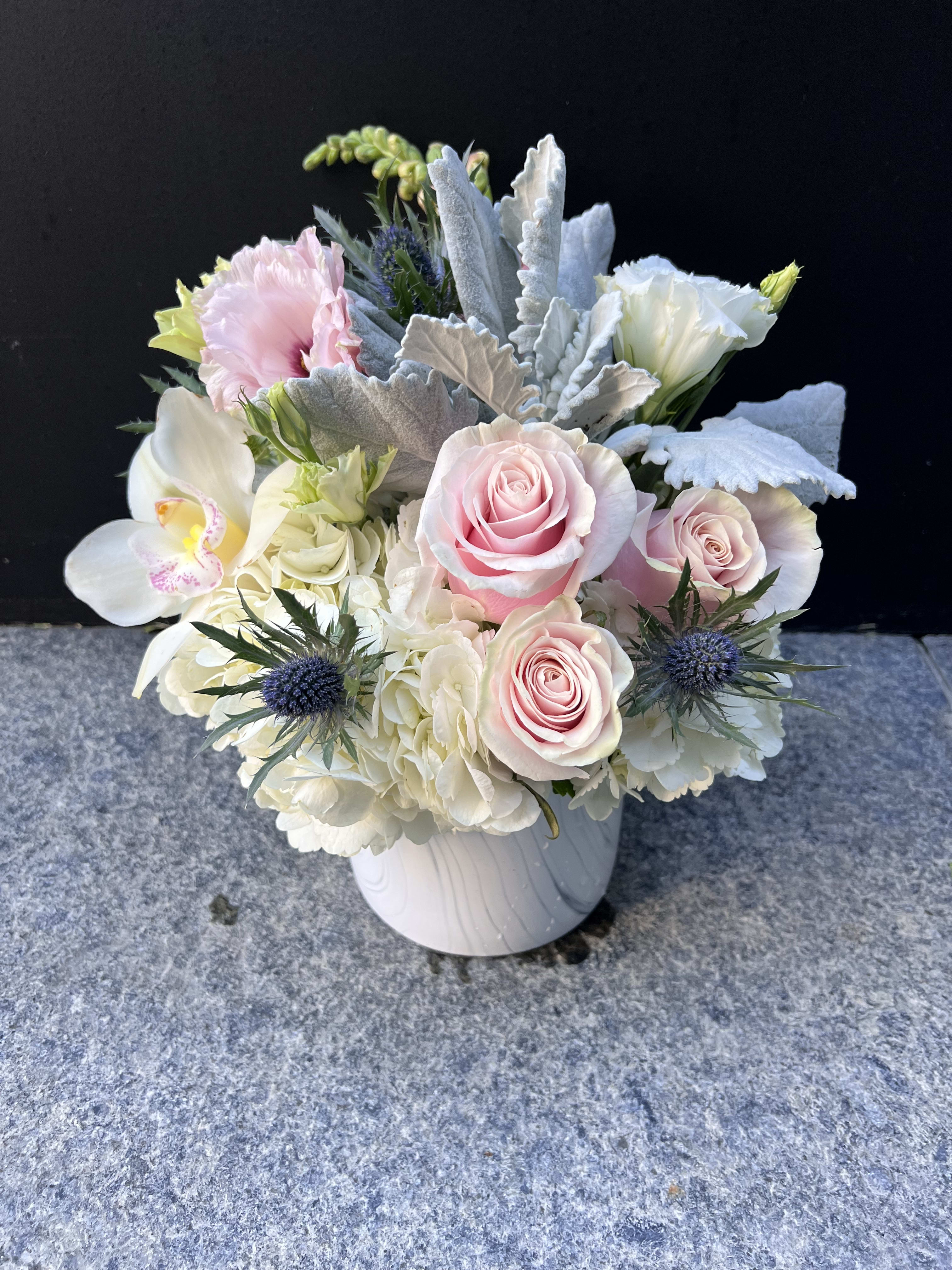 Pink roses and white orchids in a white vase