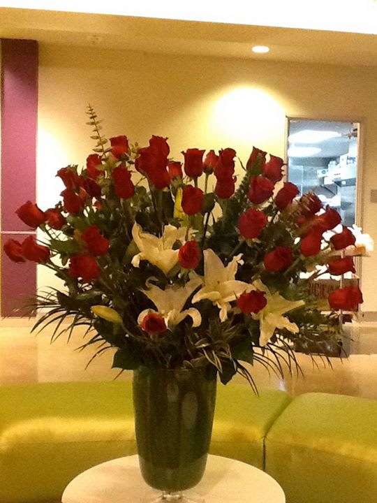 Tall vase arrangement of red roses and white lilies