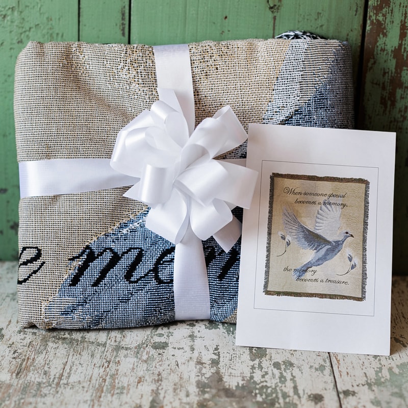 Wrapped gift with a white bow and sympathy card