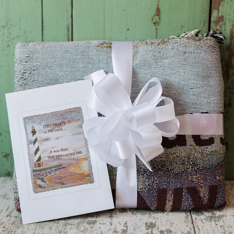 Folded textile gift with a white ribbon and greeting card