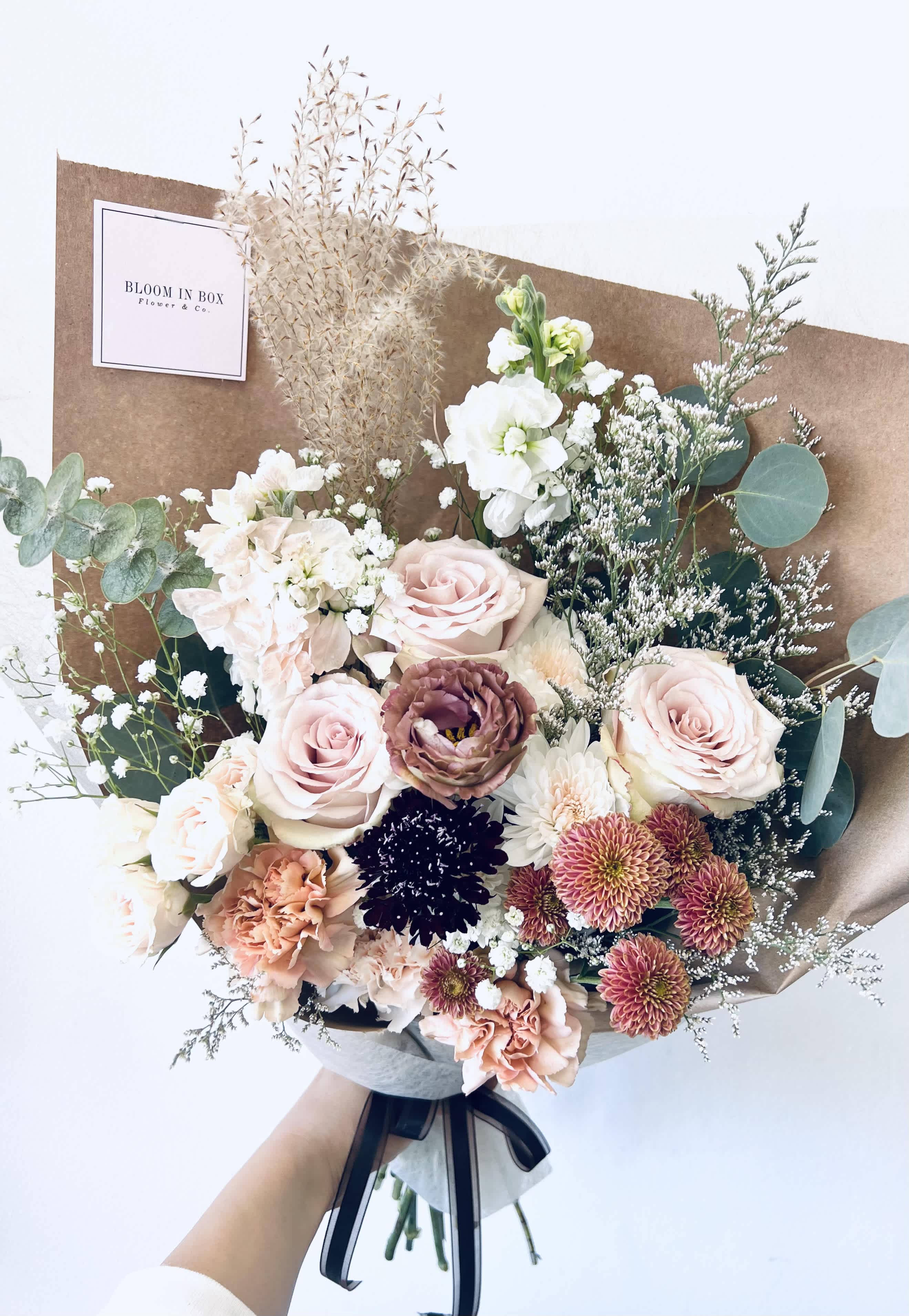 Hand-tied bouquet of pale pink and white flowers with eucalyptus